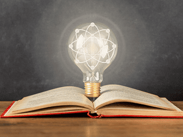 Glowing light bulb over open book representing high quality education in Philippines for MBBS students, highlighting advanced learning, knowledge development, and modern teaching methods.