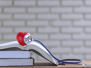 Medical books with stethoscope representing advantages of Lumbini Medical College including WHO and MCI recognition, English medium MBBS, affordable fees, global ranking, and quality clinical training facilities.