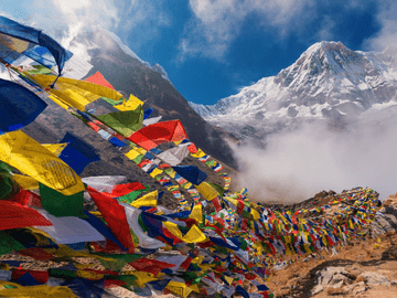Colorful prayer flags in Nepal mountains representing Birat Medical College climate with cool summers, cold winters, and diverse seasonal conditions across regions.