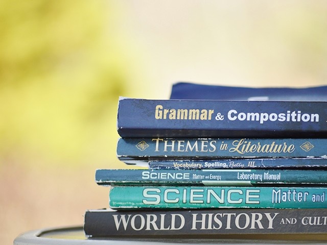 Stack of academic books including science, grammar, and world history, representing MBBS syllabus at Samarkand State Medical Institute with focus on theoretical knowledge, clinical training, and comprehensive medical education.