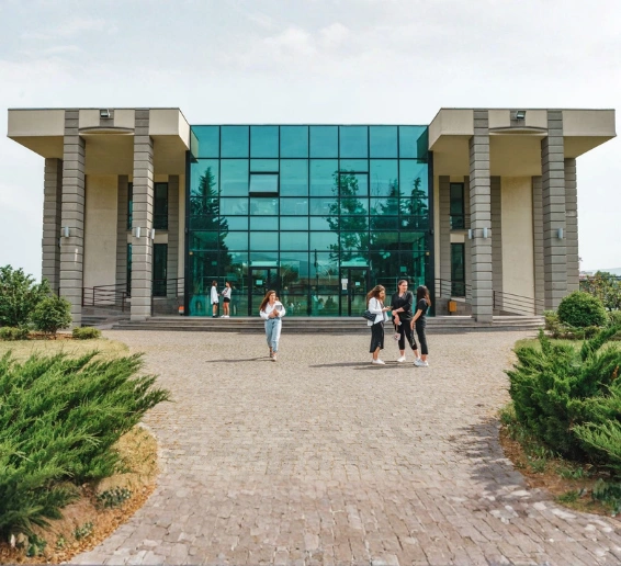 Modern Grigol Robakidze University building in Georgia with students walking on the campus pathway, highlighting one of the top MBBS colleges in Georgia for Indian students.